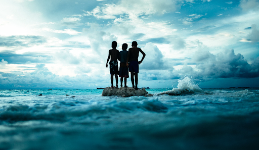 Three children in the middle of the sea